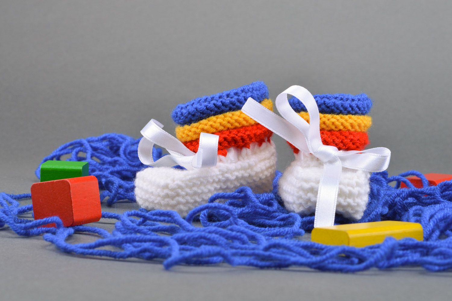 Chaussons de bébé tricotés avec aiguilles avec rubans en satin faits main photo 1