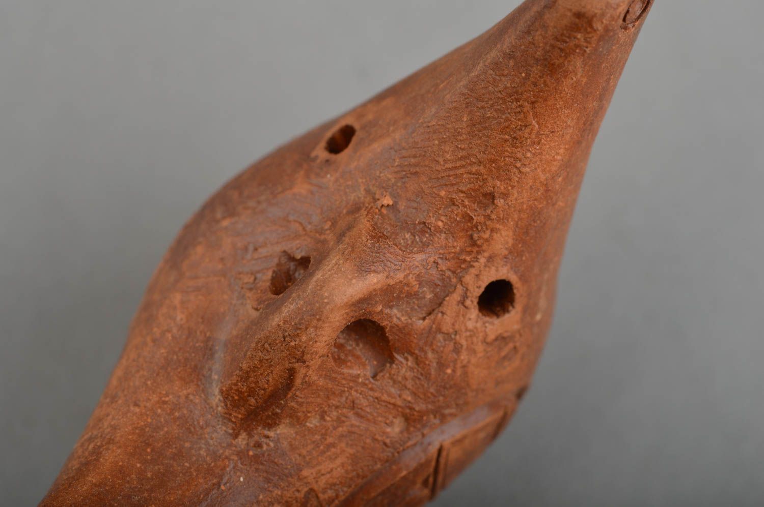 Braune handgemachte Lippenpfeife aus Ton in Form des Vogels mit zwei Löchern foto 4