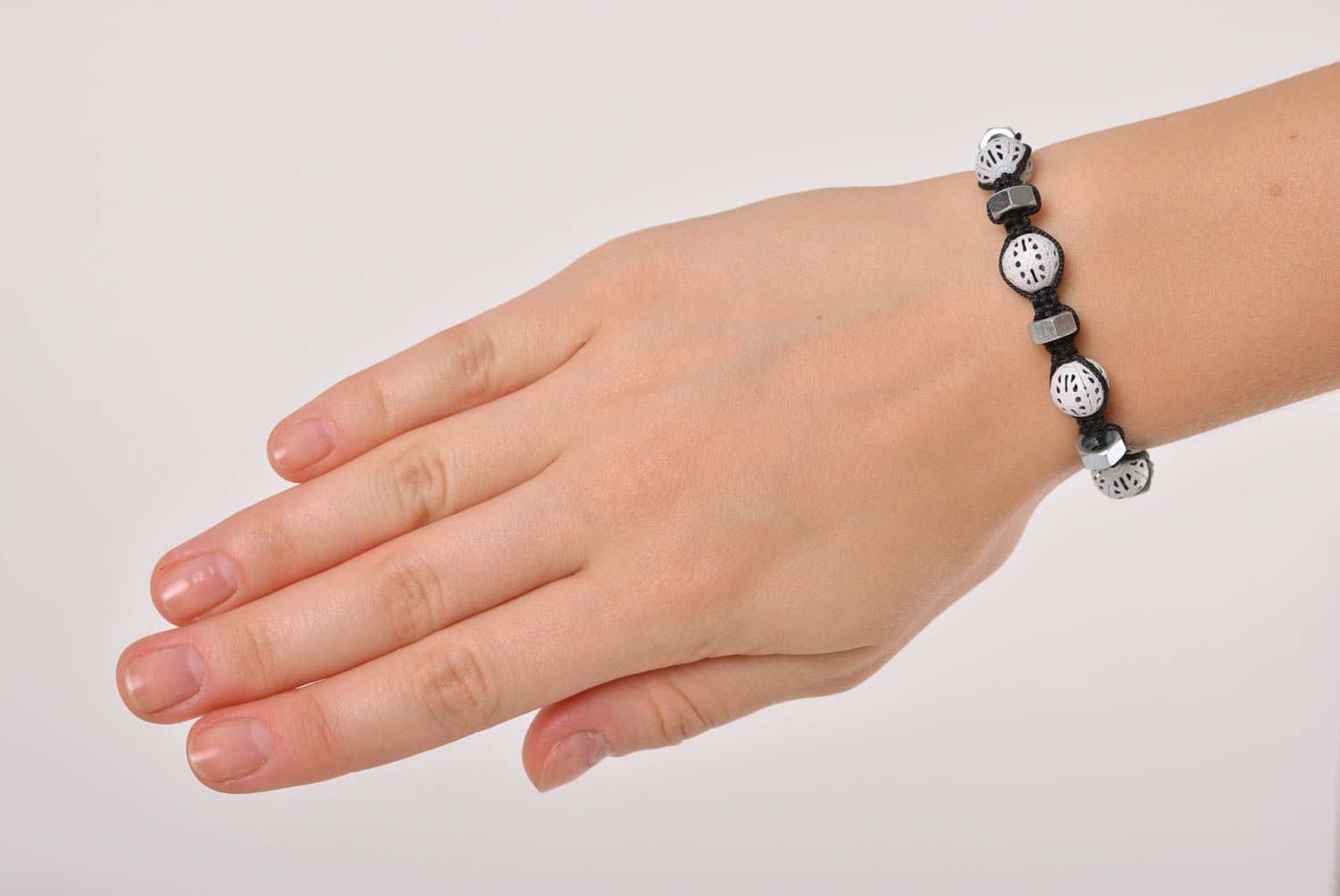 Strand black cord bracelet with white ceramic beads and female metal screws photo 3