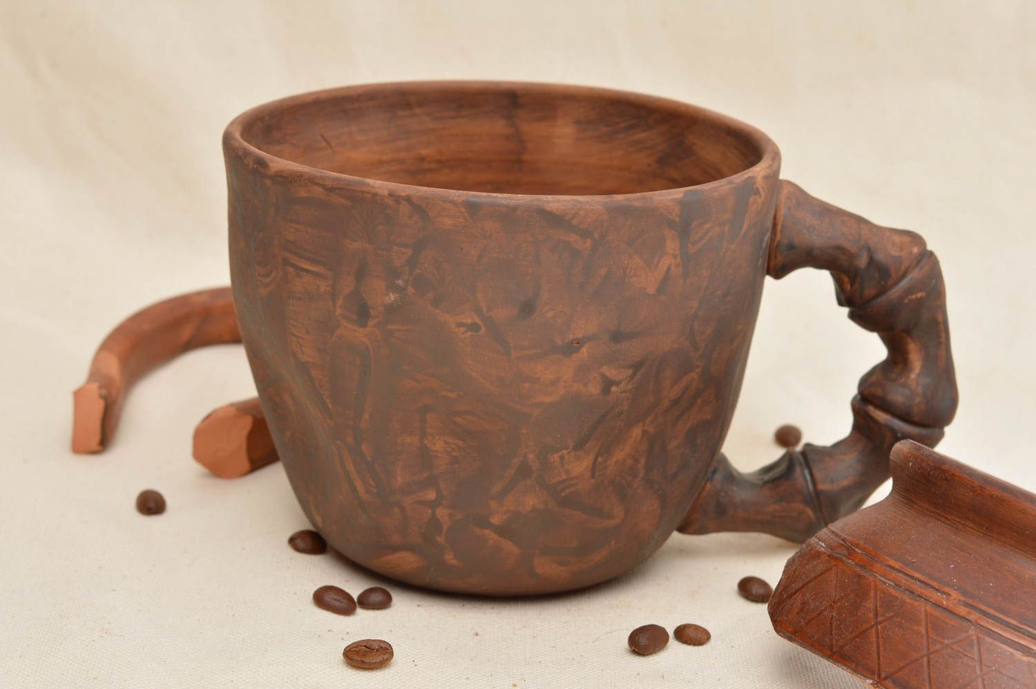 Brown clay cup with bone-shaped handle not glazed and without a pattern
 photo 1
