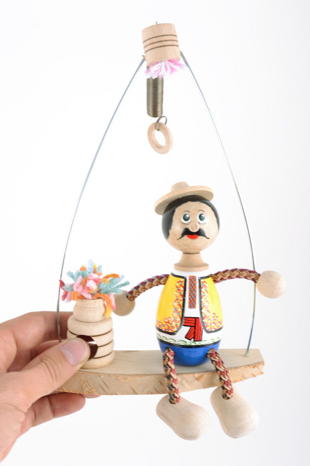 Handmade decorative wooden toy doll on a swing bench hand-decorated with paints photo 2
