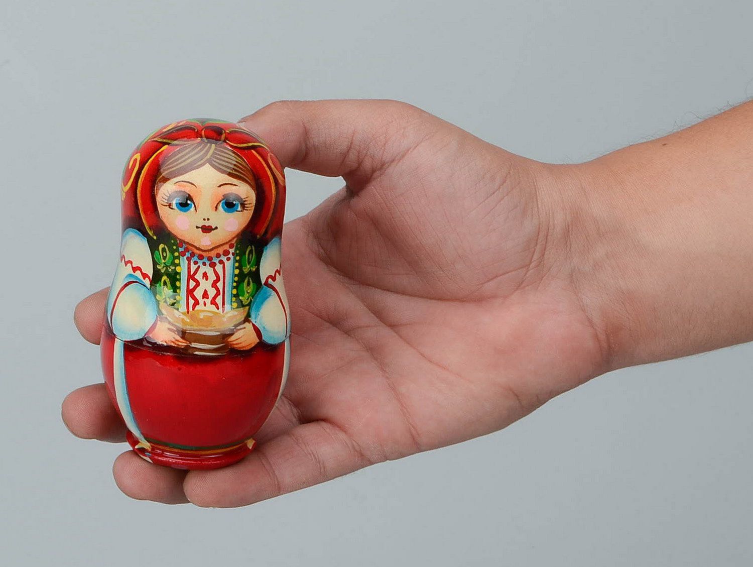 Matrioshka en una ropa nacional ucraniana con varéniki. Matrioshka es la muñeca de madera con vestido ruso campesino, que contiene otras de menor tamaño. Varéniki es una comida nacional de Ucrania
 foto 2