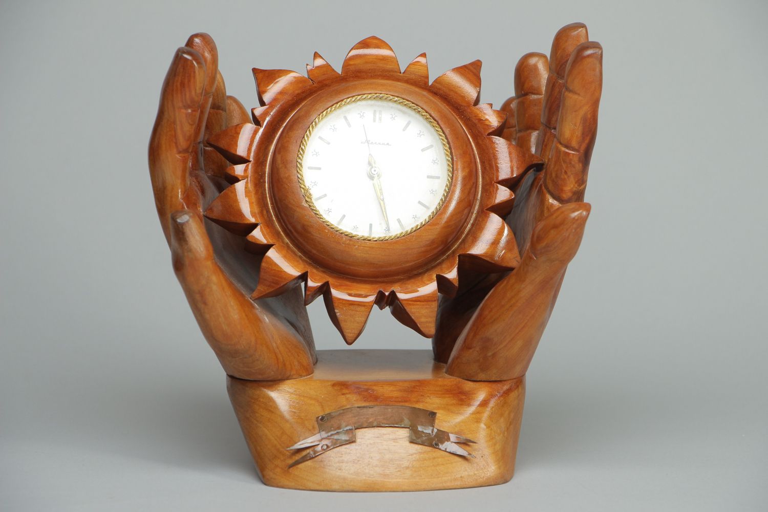 Horloge de table en bois sculpté Soleil dans les mains photo 1