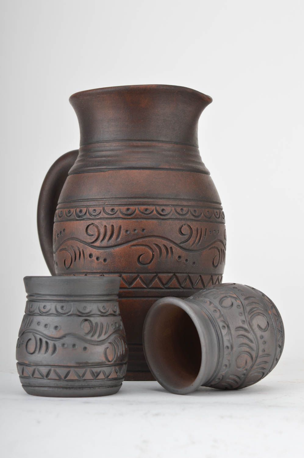 Vajilla de cerámica artesanal jarro y vasos de arcilla roja para bebidas foto 2