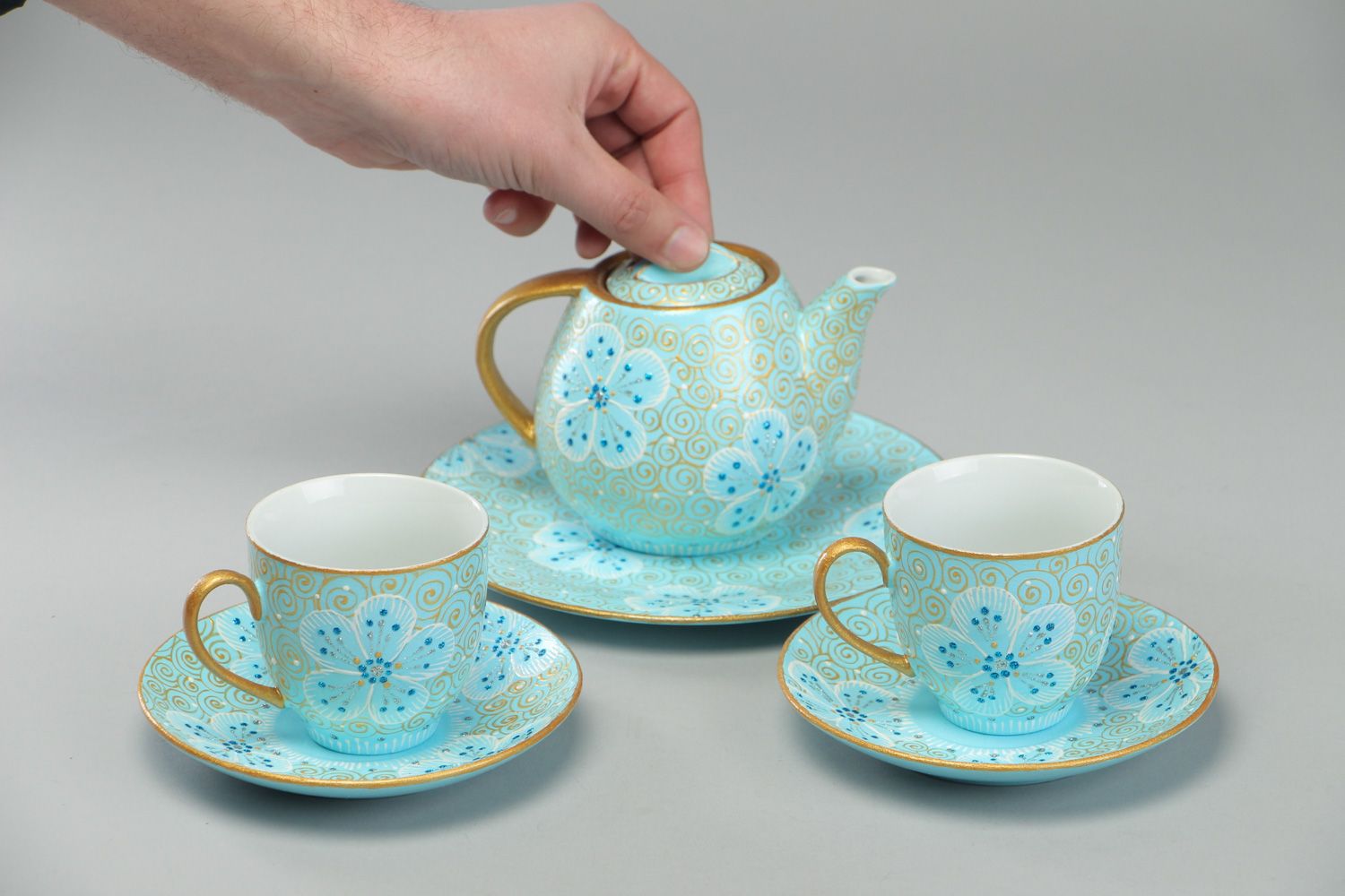 Hand-painted ceramic tea set in blue and gold colors teapot and two cups with handles and saucers photo 4