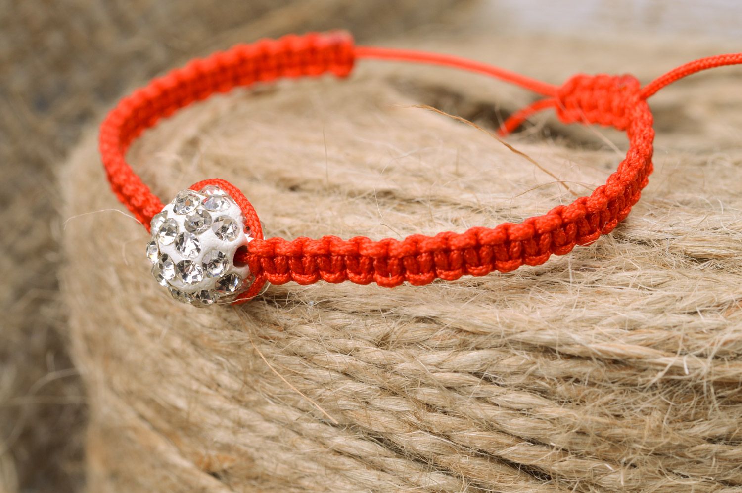 Red and white handmade wrist bracelet woven of threads and a bead photo 1