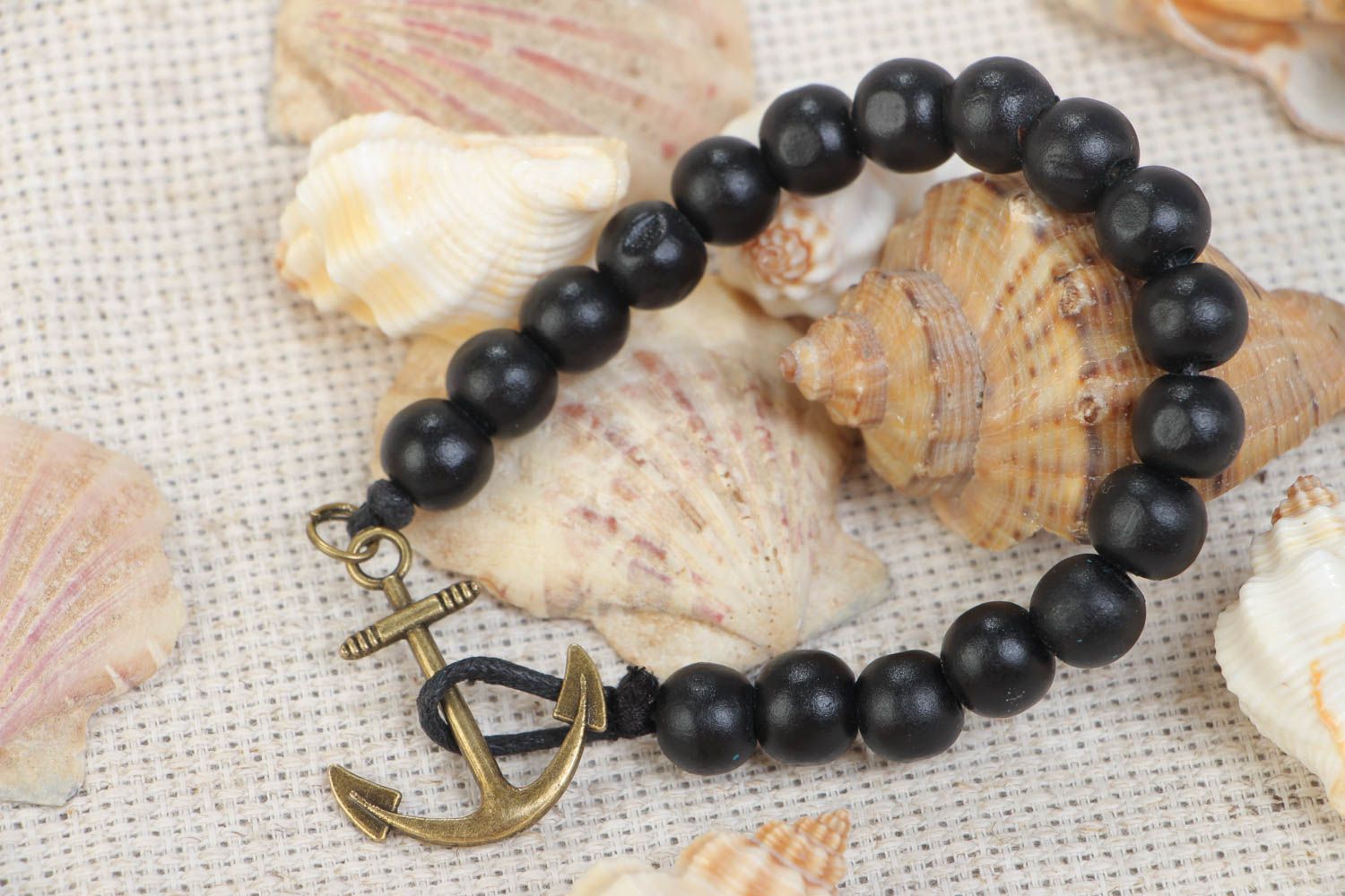 Handmade stylish black bracelet made of wooden beads with metal anchor photo 1