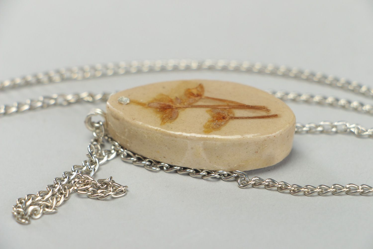 Handmade light oval pendant with flowers embedded in epoxy resin on long chain photo 3