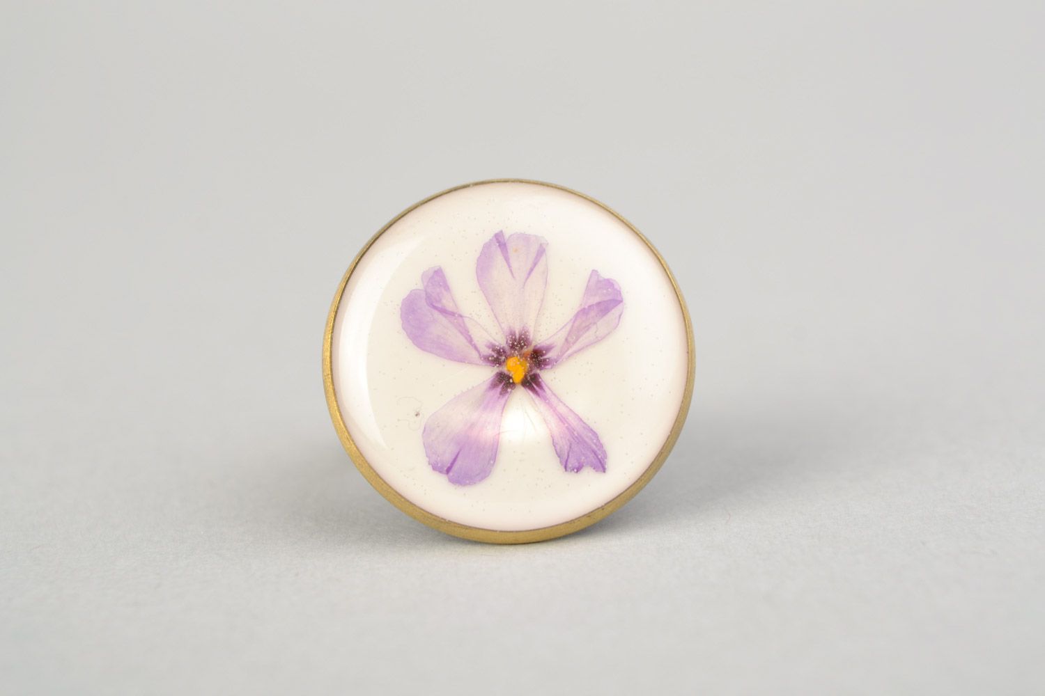 Handmade round ring with natural flowers on white background in epoxy resin photo 3