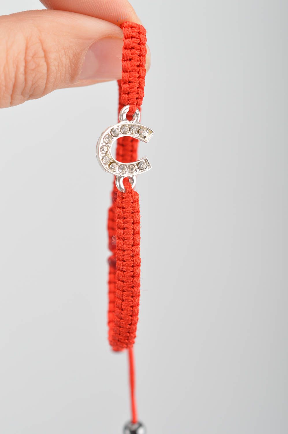 Dünnes rotes geflochtenes Armband aus Faden mit metallischem Hufeisen für Glück foto 8