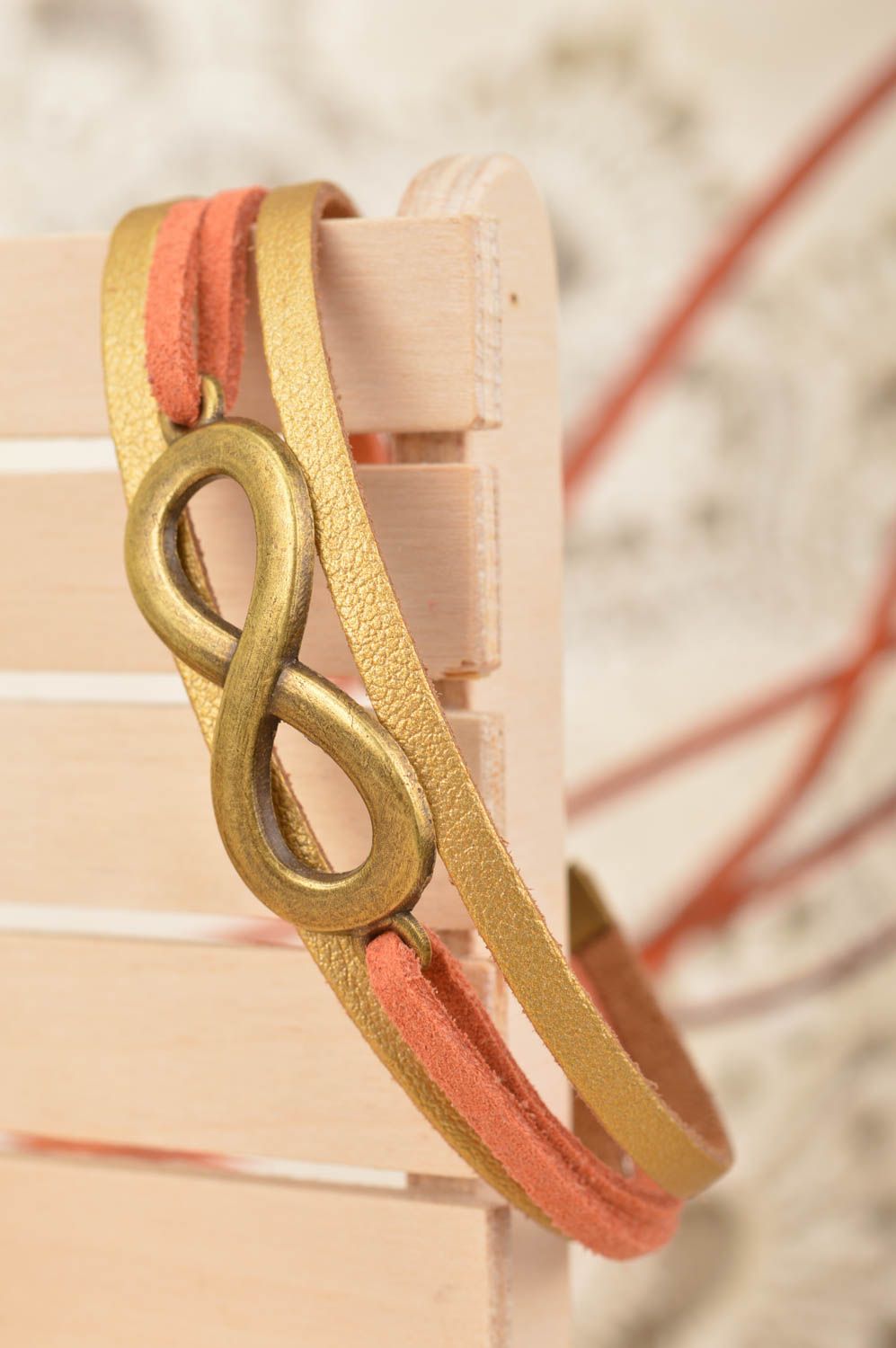 Pulsera artesanal de cordones de gamuza dorada con inserciones infinidad  foto 1