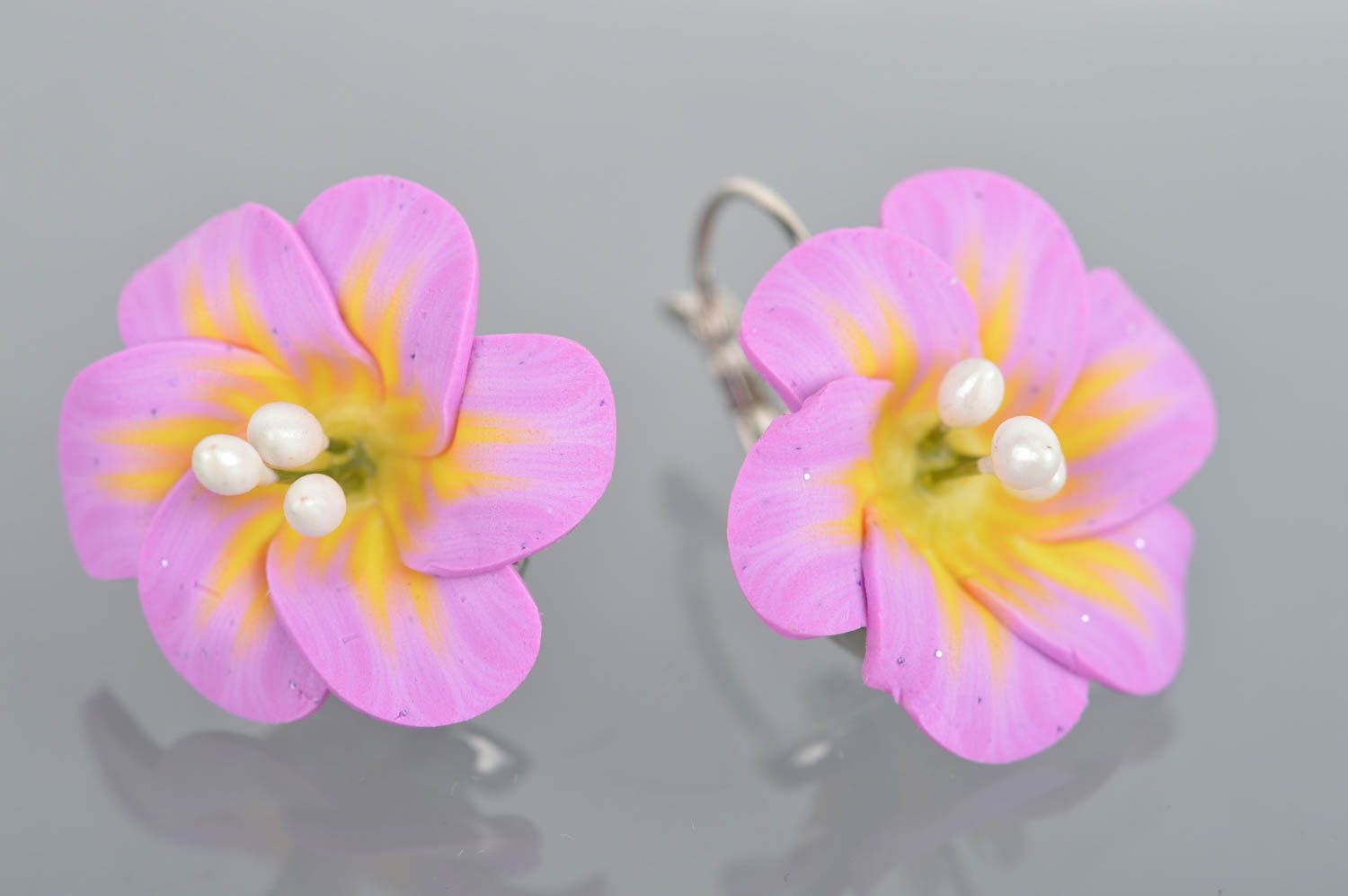 Feine helle violette originelle handgemachte Ohrringe aus Polymerton mit Blumen foto 2