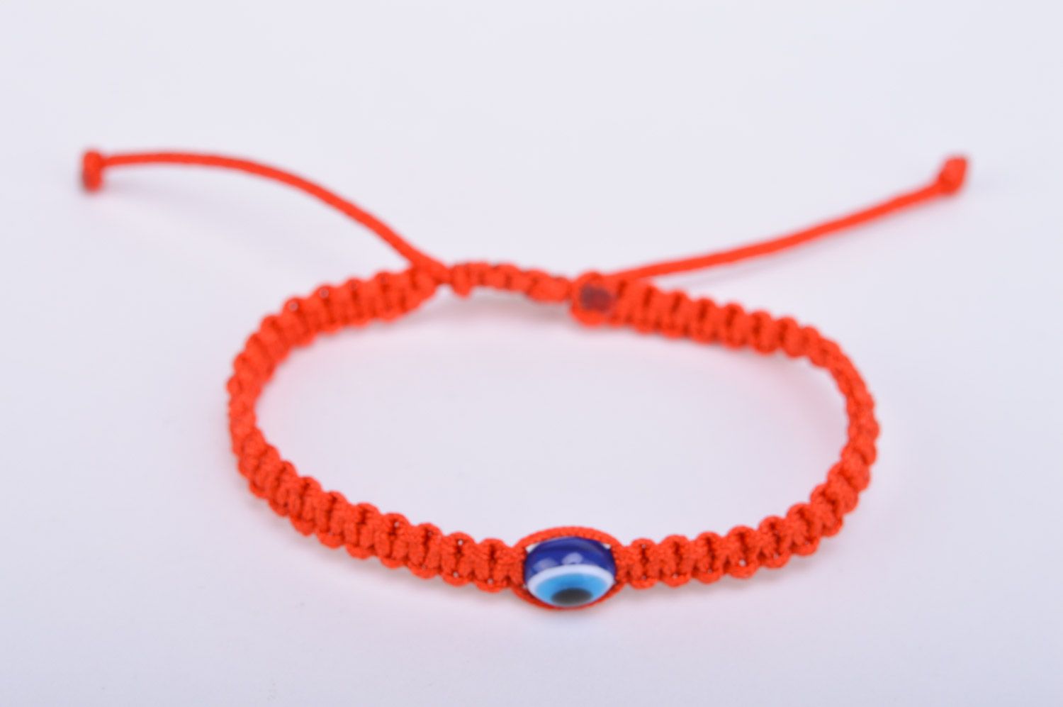 Braided handmade red wrist bracelet made of threads against the evil eye photo 2