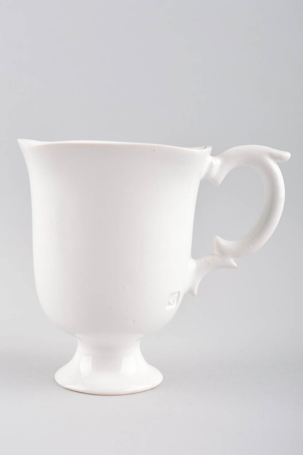 White plain porcelain teacup on the stand in elegant design with handle and saucer photo 5