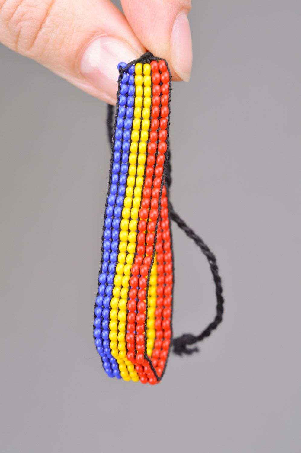 Beautiful stylish handmade women's wrist bracelet woven of three-colored beads and threads photo 3