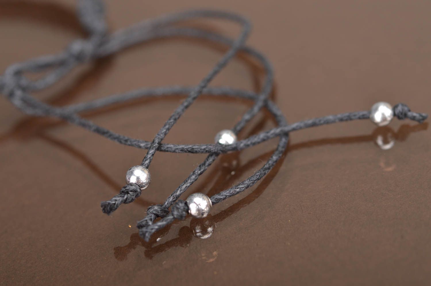 Тонкий черный плетеный браслет на руку из шнурка с белой бусиной и фурнитурой фото 5