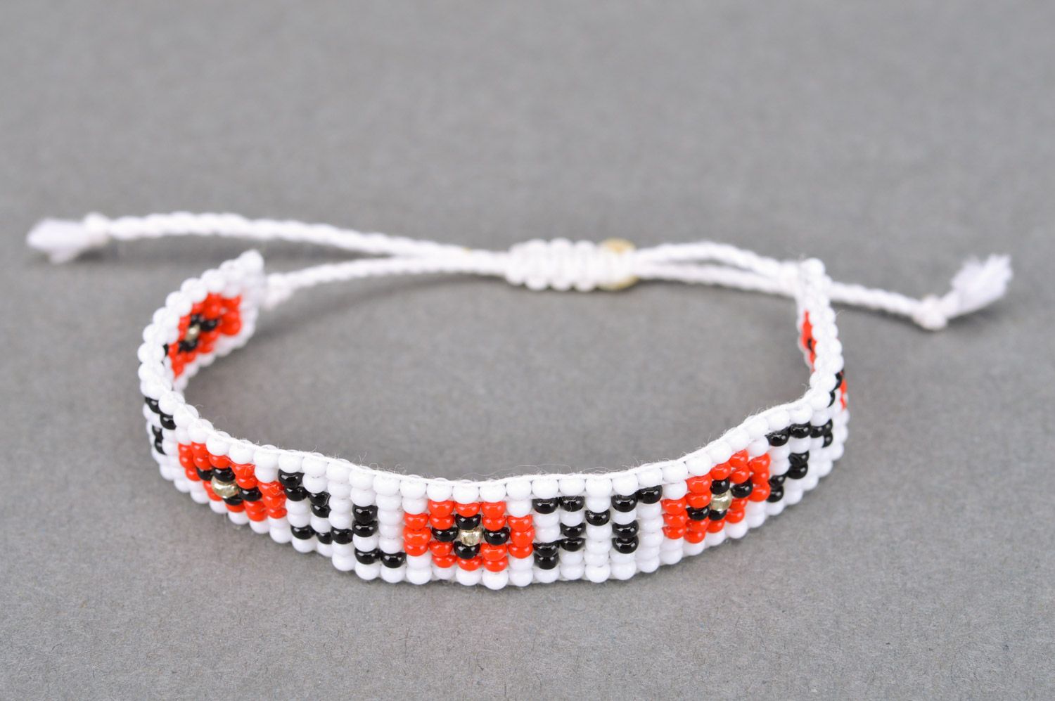 Handmade wrist bracelet woven of black white and red beads with ethnic ornament photo 2