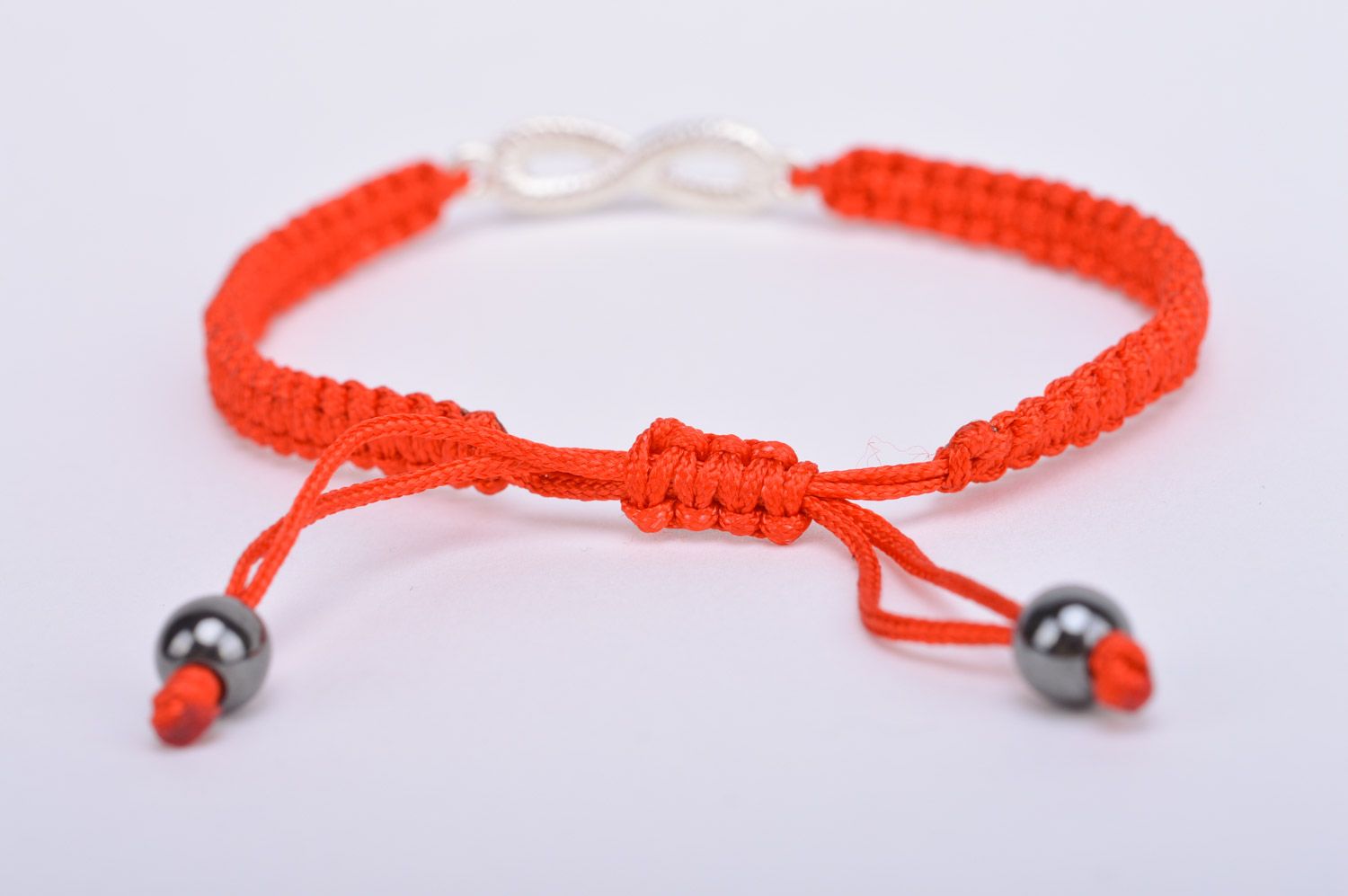 Handmade thin friendship wrist bracelet woven of red threads with infinity sign photo 5