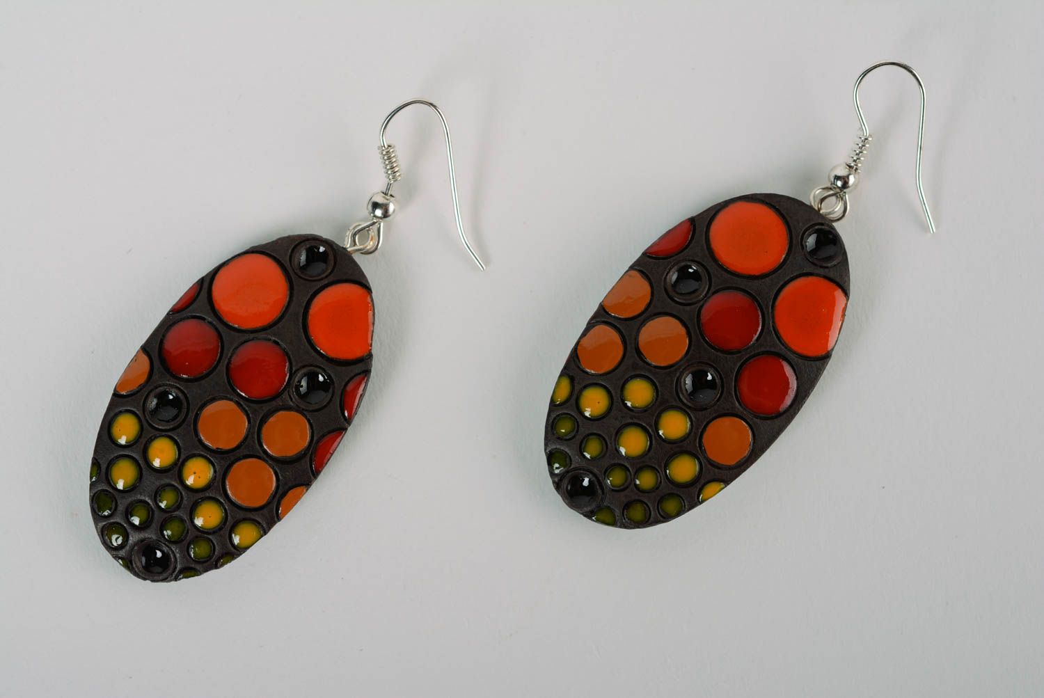 Boucles d'oreilles en argile peintes d'émail faites main ovales noir-orange photo 1