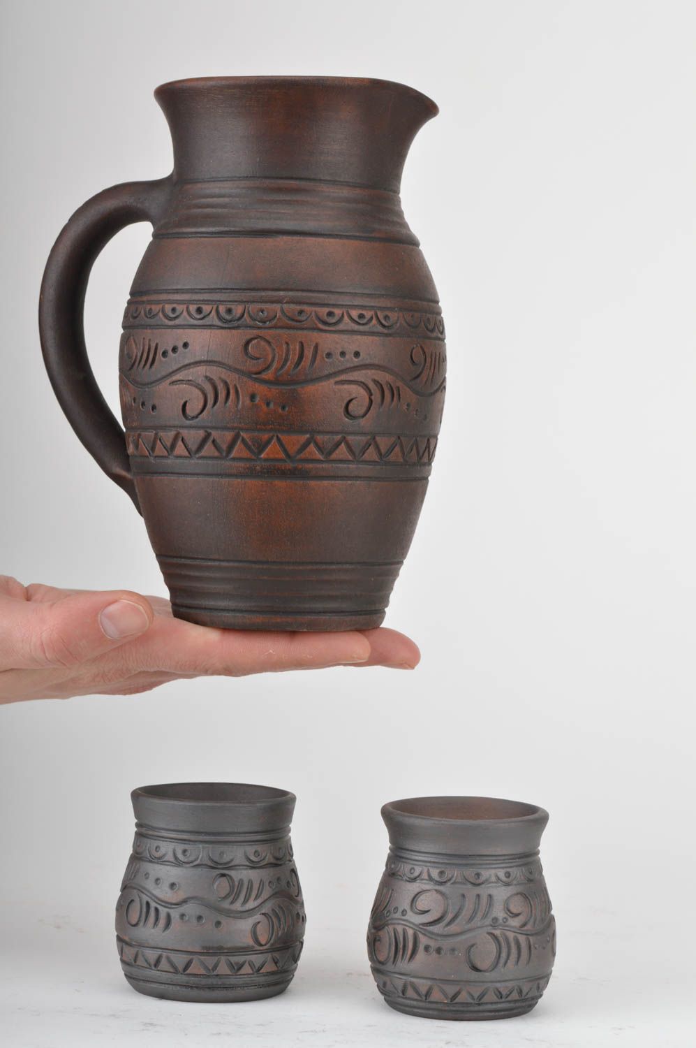 Vajilla de cerámica artesanal jarro y vasos de arcilla roja para bebidas foto 3