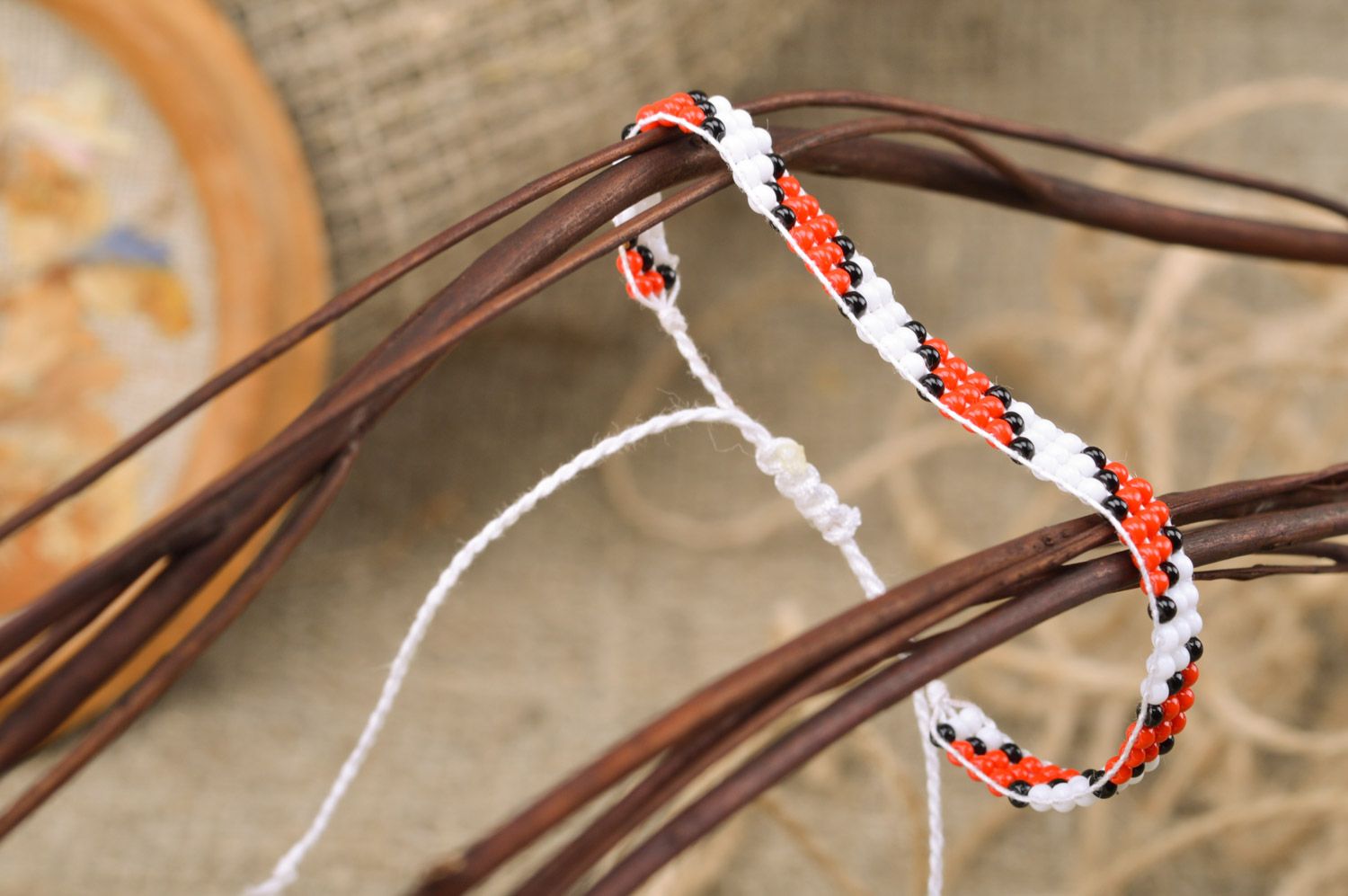 Pulsera de abalorios estrecha en cordones con ornamento rojinegro artesanal  foto 1