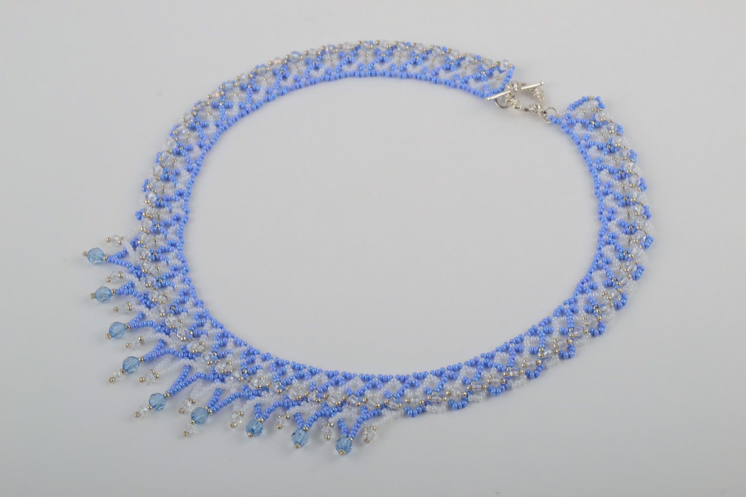 Handmade women's beaded necklace with charms of blue color photo 1