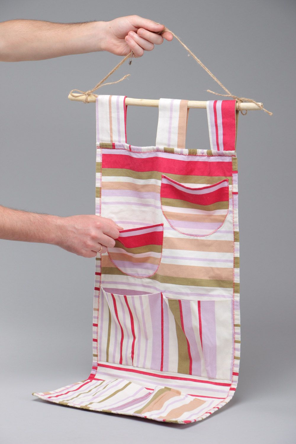 Bright handmade hanging wall pocket organizer sewn of fabric on wooden plank photo 5