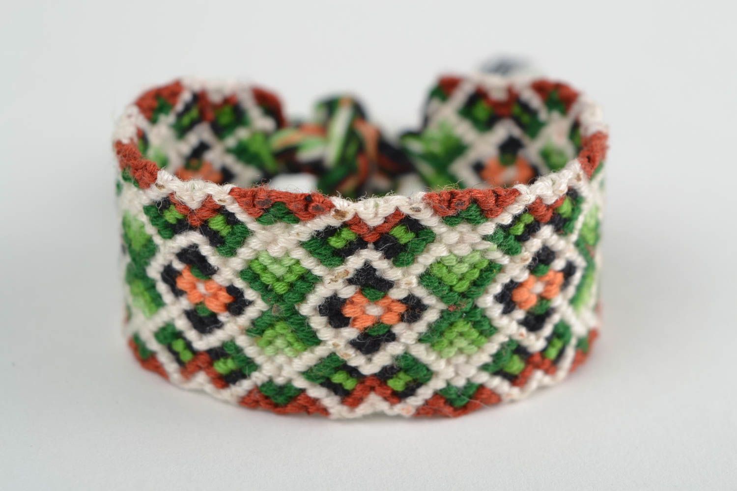 Handmade designer friendship bracelet with green and white geometric ornament  photo 3