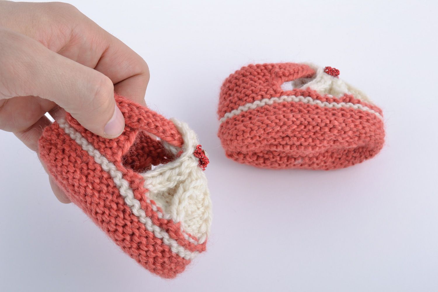 Helle weiße und rosafarbige handgemachte Babyschuhe aus Wolle in Form von Sandalen foto 5