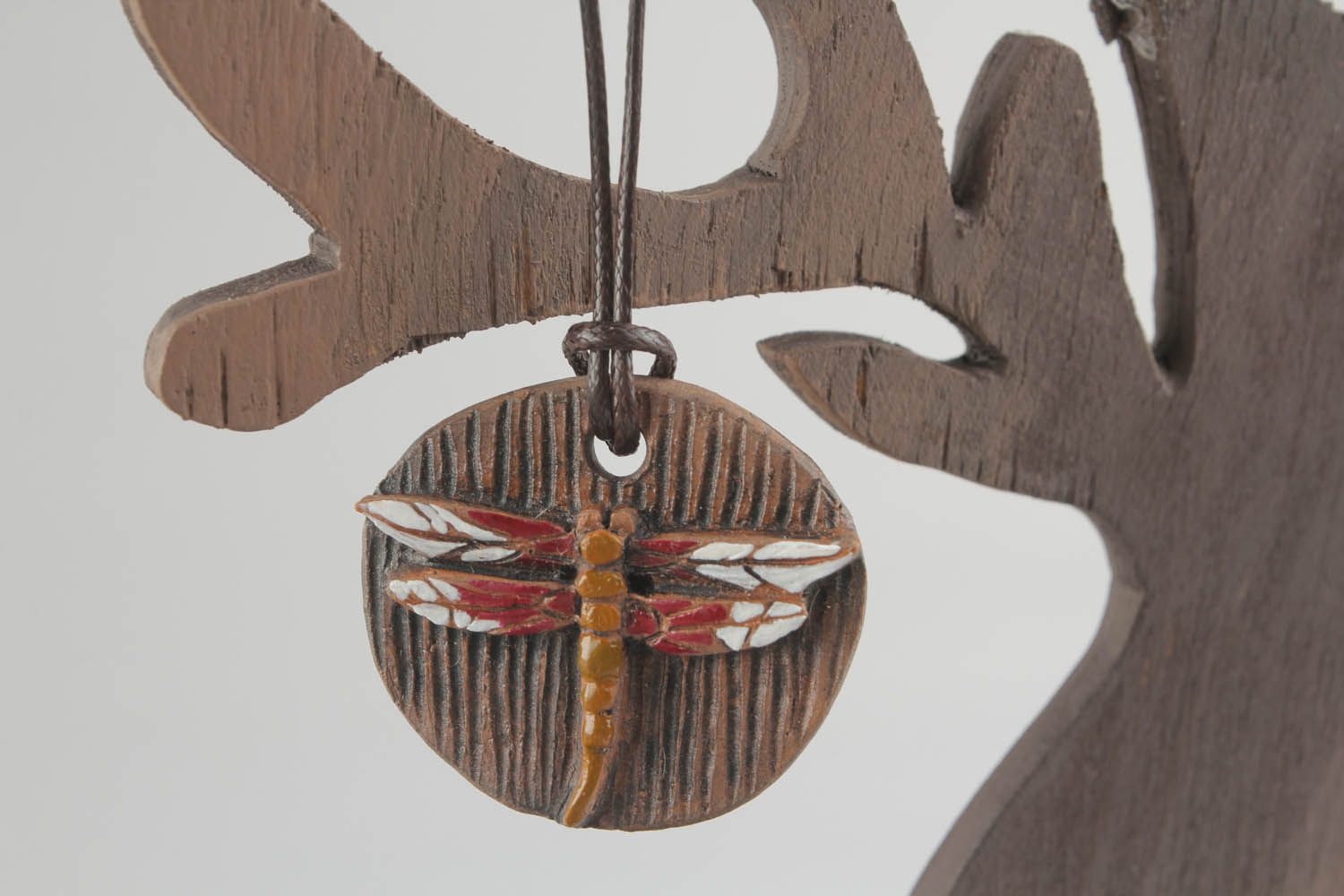 Pingente redondo de argila pintado com tintas acrílicas decorado com a imagem de uma libélula foto 1