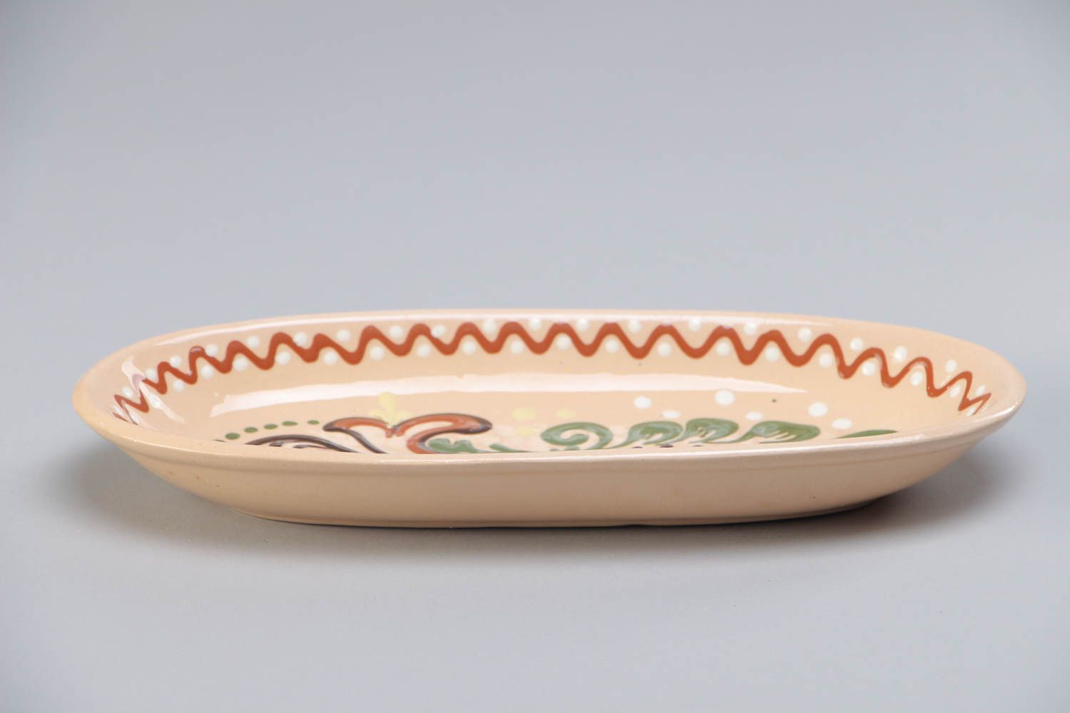 Homemade long ceramic dish ornamented with colorful glaze for serving fish photo 2