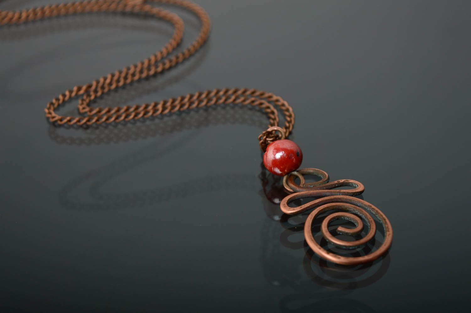 Twisted copper pendant with coral bead photo 1