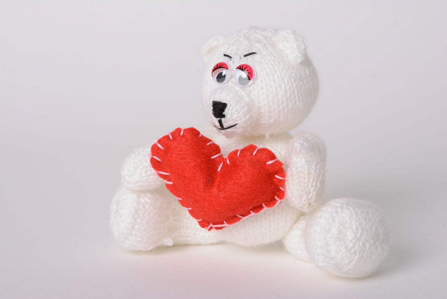 Small handmade soft knitted toy bear with red heart photo 1