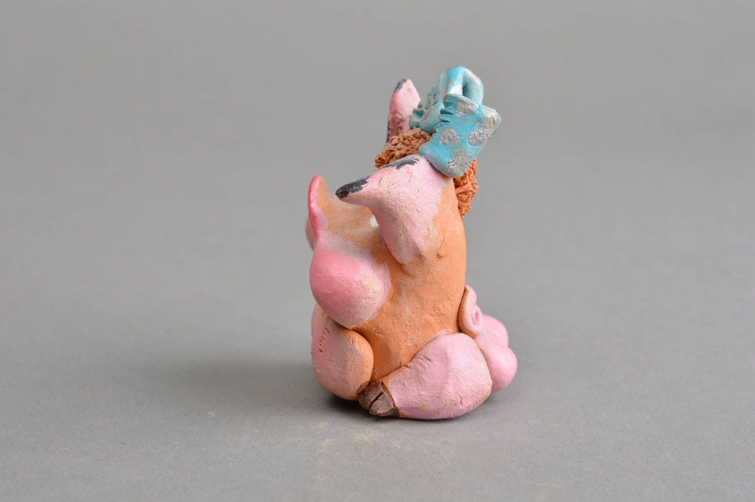 Керамический сувенир ручной работы задумчивая свинка розовая с голубым бантом фото 3