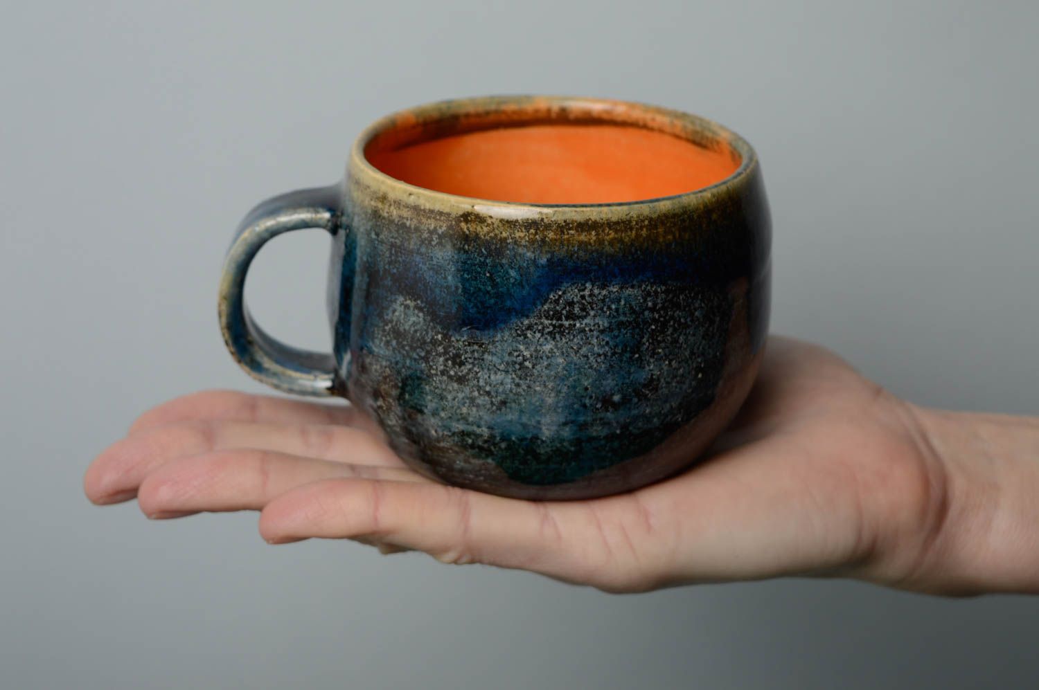 Glazed ceramic handmade coffee cup in deep blue and orange color with handle photo 5