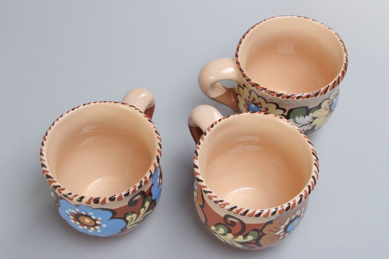 Set of three glazed village-style tea cups with painted flower pattern photo 3