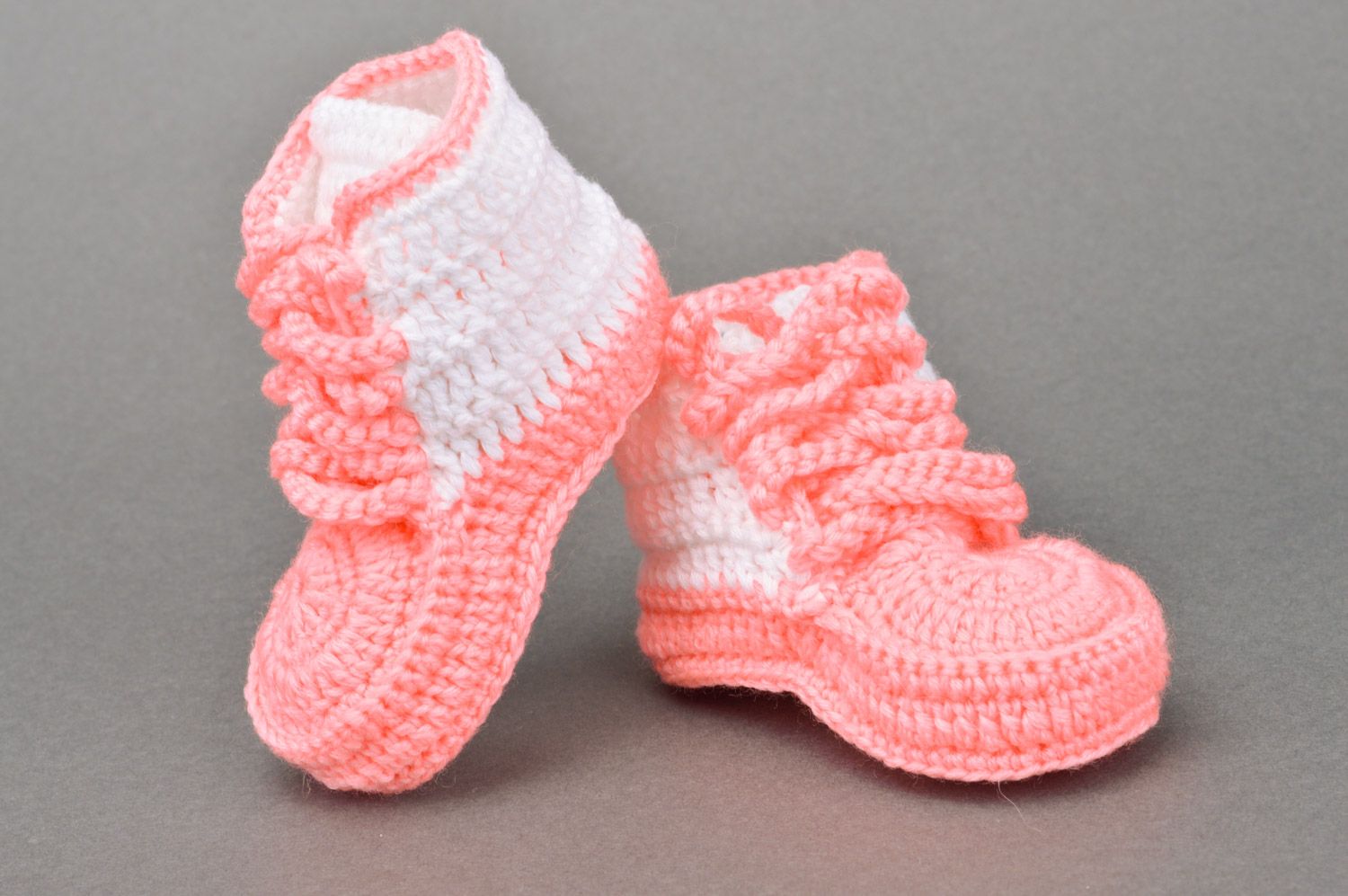 Schöne rosafarbige gehäkelte Babyschuhe mit Schuhbändern in Form der Turnschuhen foto 2