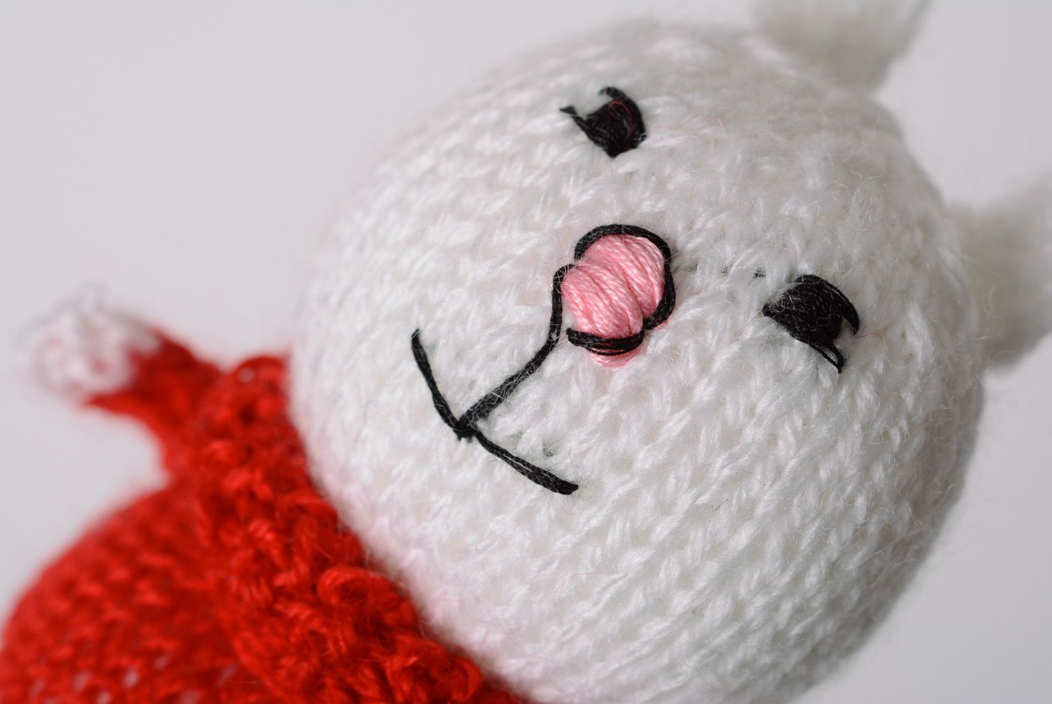 Juguete de peluche liebre blanca en suéter rojo tejido pequeño artesanal foto 2