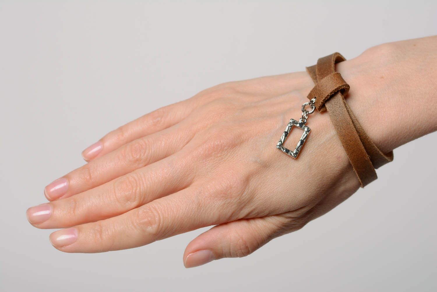 Bracelet fait main réalisé de cuir naturel marron avec pendeloque métallique photo 3