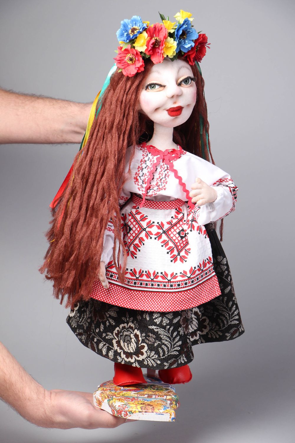 Muñeca de peluche en traje nacional en soporte foto 4