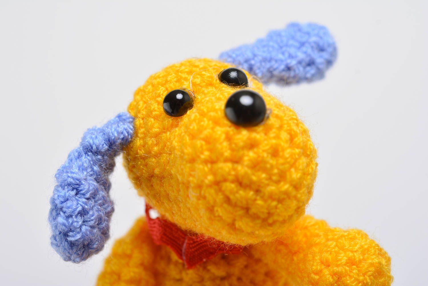 Gelbes handmade Kuscheltier Hund aus Acrylfäden gehäkelt mit blauen Ohren foto 2
