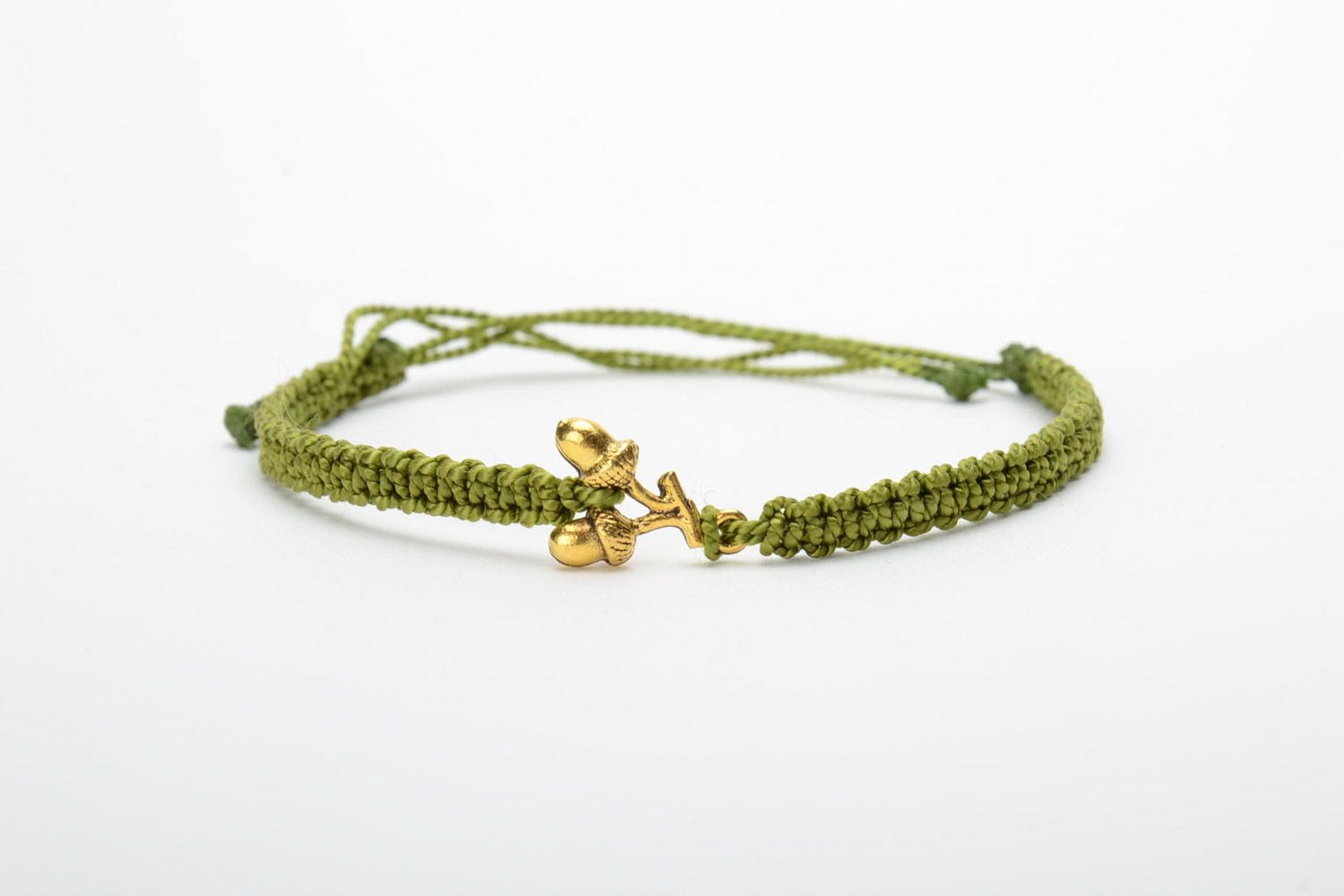 Women's handmade macrame woven thread bracelet of green color with metal charms in the shape of acorns photo 5