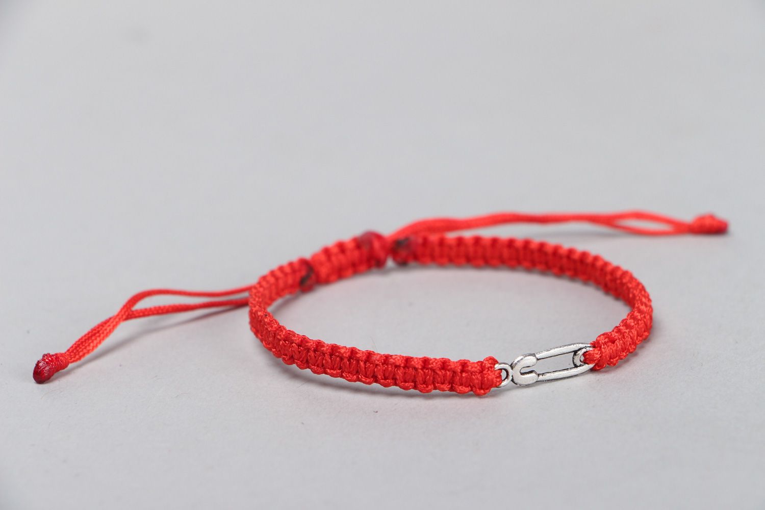Handmade friendship bracelet woven of synthetic thread of red color with ties photo 2