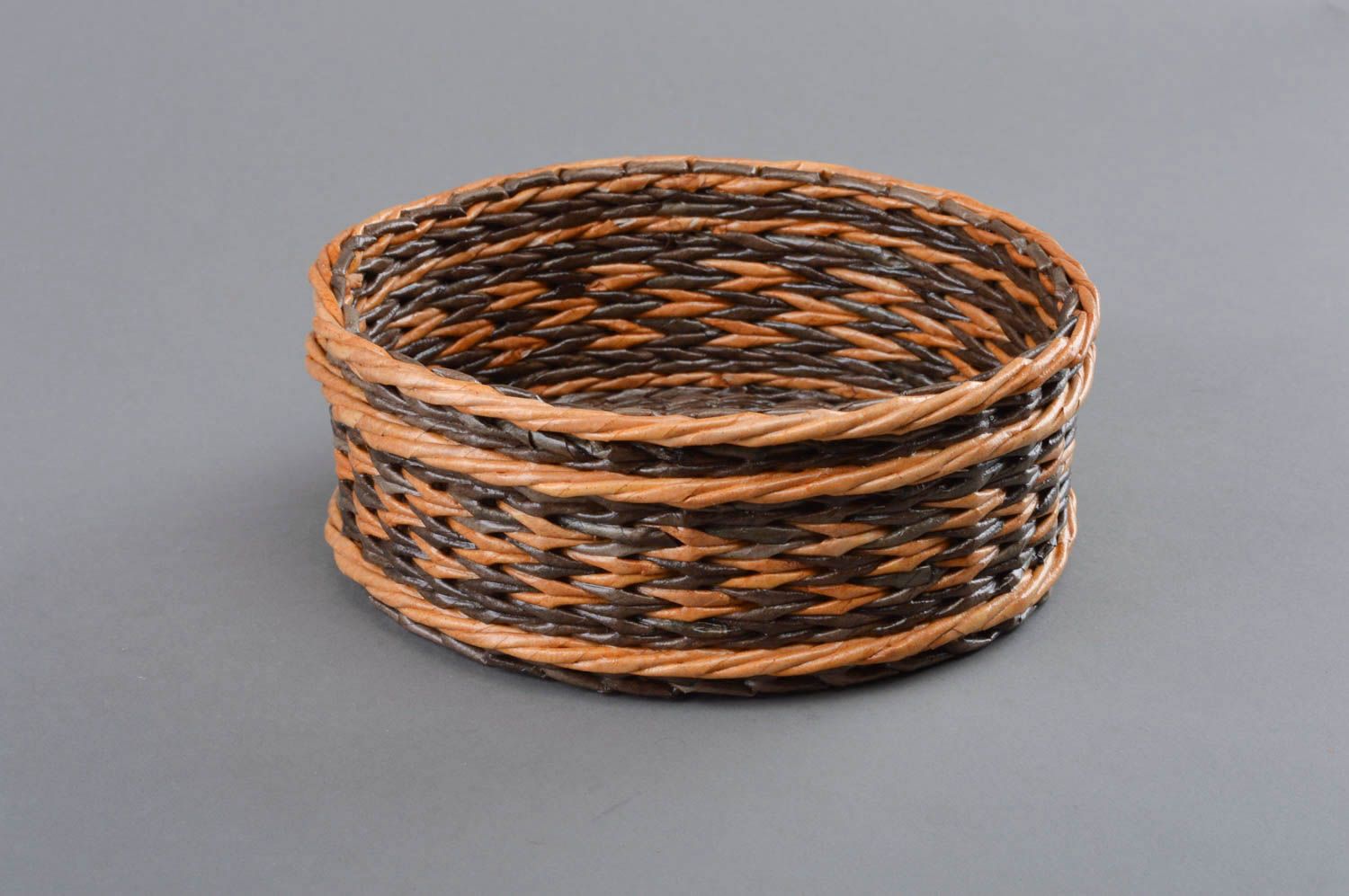 Handmade decorative round two colored brown basket woven of paper tubes photo 1