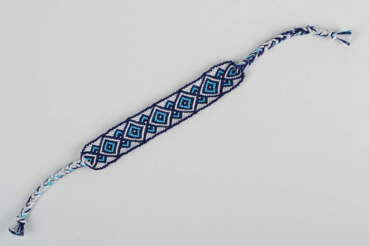 Handmade macrame bracelet woven of white and blue embroidery floss with ornament photo 5