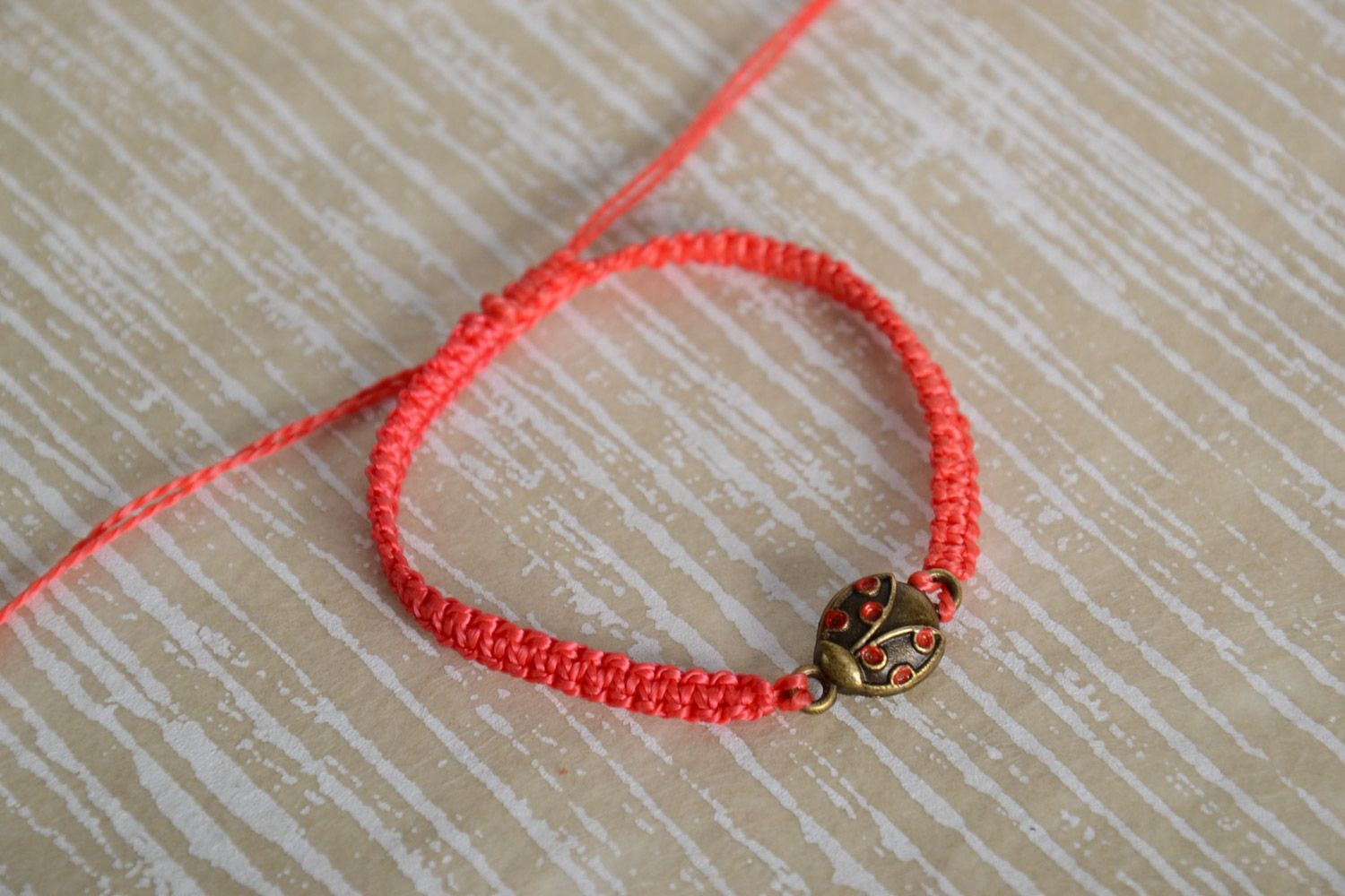 Handmade women's macrame woven cord bracelet of red color with charm photo 1