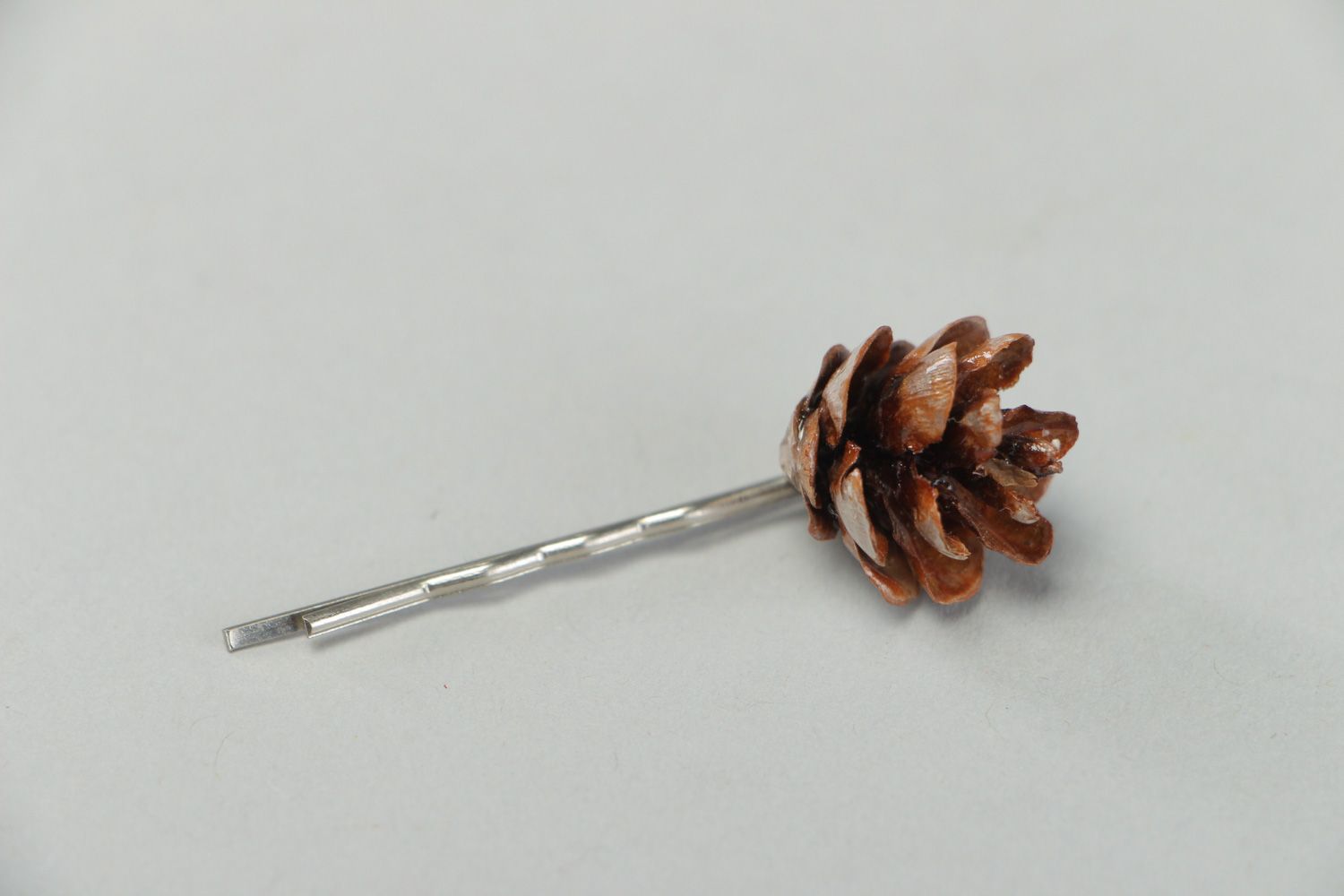 Handmade small metal hair pin with natural cone coated with epoxy resin  photo 1
