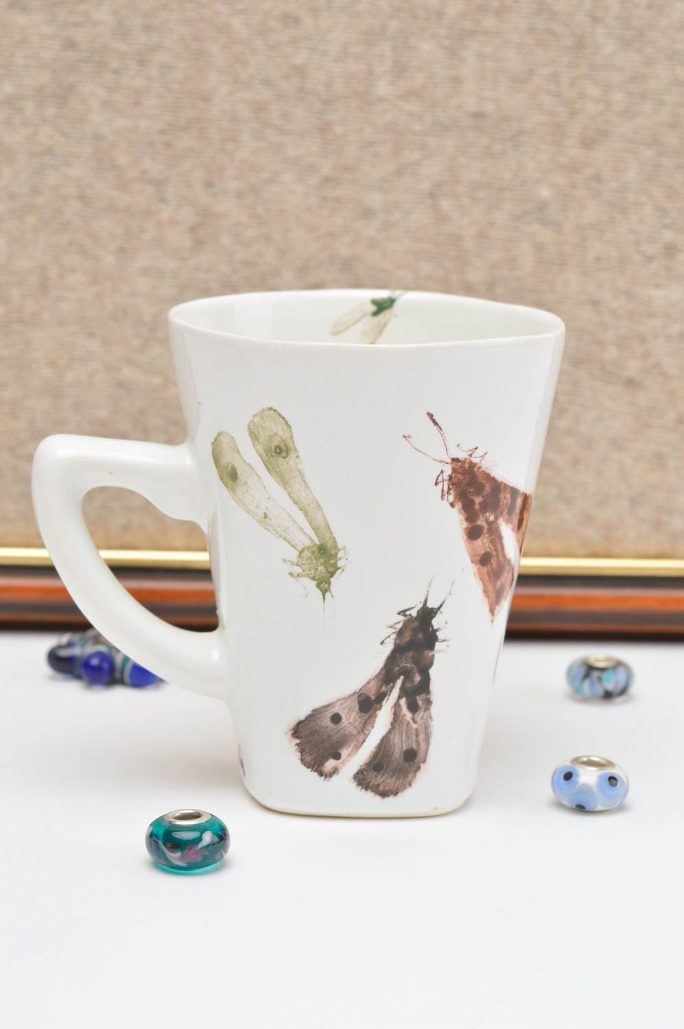 White ceramic teacup with handle and insects prints photo 1