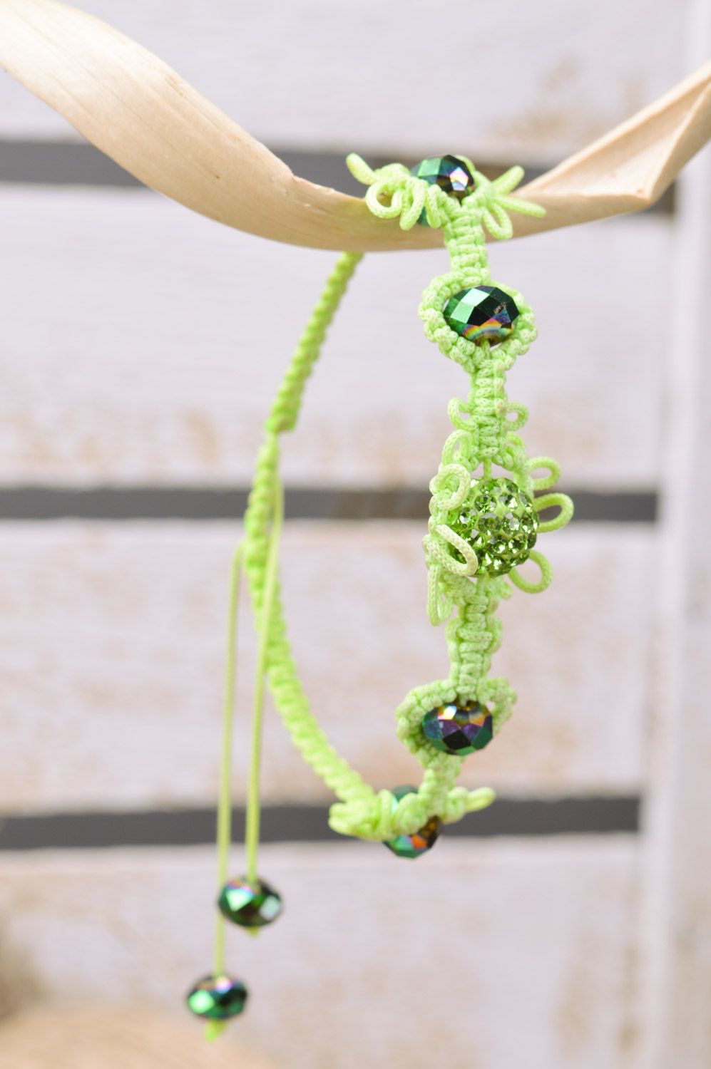 Stylish handmade women's wrist bracelet woven of threads and beads of lime color photo 1