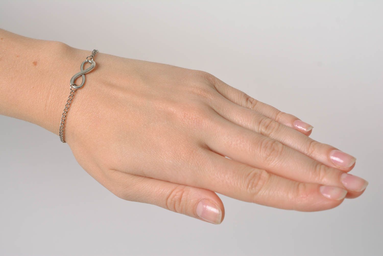 Handmade designer wrist bracelet with metal chain and infinity shaped insert photo 2